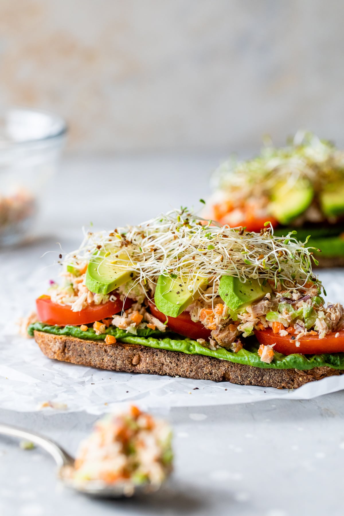 healthy tuna sandwich with avocado and sprouts