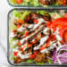 Halal Food Cart inspired chicken served over a big salad of lettuce and tomatoes drizzled with a yummy white sauce.