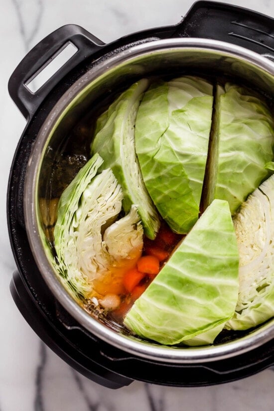 Cabbage in an instant pot on top of carrots and beef brisket