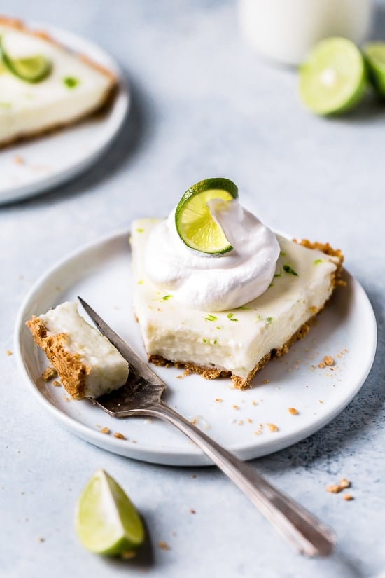 This easy Key Lime Yogurt Pie is a cross between a key lime pie and a key lime cheesecake with a light, creamy filling that is sweet and tart, made with key lime juice, yogurt and cream cheese in a graham cracker crust.