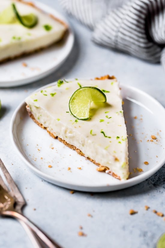 This easy Key Lime Yogurt Pie is a cross between a key lime pie and a key lime cheesecake with a light, creamy filling that is sweet and tart, made with key lime juice, yogurt and cream cheese in a graham cracker crust.
