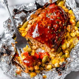 These Campfire Meatloaf Foil Packets are great for camping, glamping or for an easy weeknight dinner. Each packet has individual turkey meatloaves slathered with BBQ sauce cooked over summer succotash.