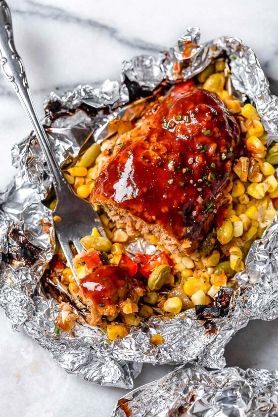 These Campfire Meatloaf Foil Packets are perfect for camping, glamping, or a quick weekday dinner. Each packet contains an individual turkey meatloaf drizzled with BBQ sauce cooked in a summer succotash.
