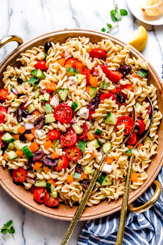 Greek Pasta Salad is light and fresh, loaded with garden tomatoes, bell peppers and cucumbers tossed in a homemade Greek dressing with Kalamata olives and Feta cheese. Perfect for summer parties or potlucks!