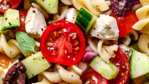 Greek Pasta Salad is light and fresh, loaded with garden tomatoes, bell peppers and cucumbers tossed in a homemade Greek dressing with Kalamata olives and Feta cheese. Perfect for summer parties!