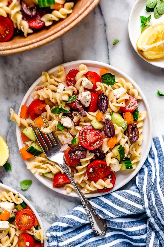 This Greek Pasta Salad is light and fresh, loaded with garden tomatoes, bell peppers and cucumbers tossed in a homemade Greek dressing with Kalamata olives and Feta cheese. Perfect for summer parties or potlucks!