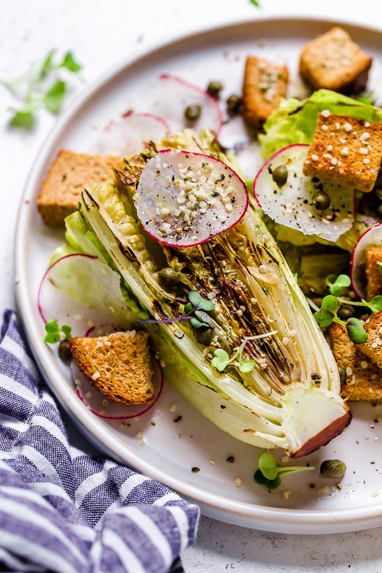 Grilled romaine makes this salad a standout! You’ll love the creamy vegan Caesar dressing, which is made with raw cashews instead of egg. Plate of vegan Caesar salad with grilled romaine.
