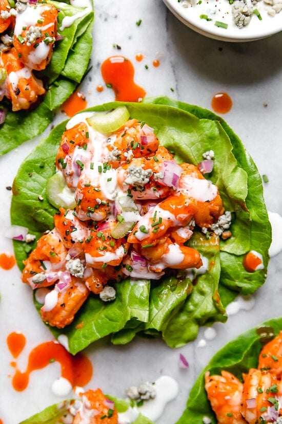 Dessa enkla, barbariga Buffalo Shrimp Salat Wraps är kryddiga, lätta och läckra toppade med selleri och ädelost eller ranchdressing.
