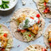 Tzatziki Fish Tacos have a Greek twist! Crisp breaded fish fillets served on tortillas topped with tzatziki sauce made with Greek yogurt, cucumbers and fresh herbs.