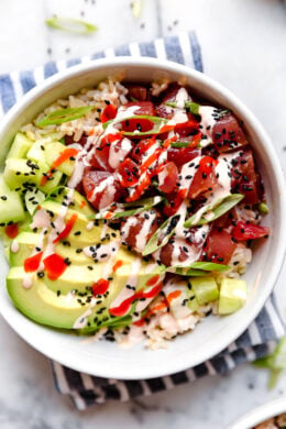 Spicy Tuna Poke Bowls made with chunks of fresh tuna, avocado, cucumbers, spicy mayo, scallions cut on the bias served on a bed of steamed rice.