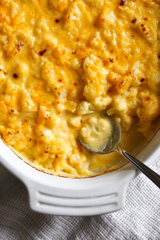 Cheesy Baked Cauliflower "Mac" and Cheese is perfect when you're craving macaroni and cheese–without the pasta! It's lower in carbs and each bowl has a healthy amount of vegetables and protein!