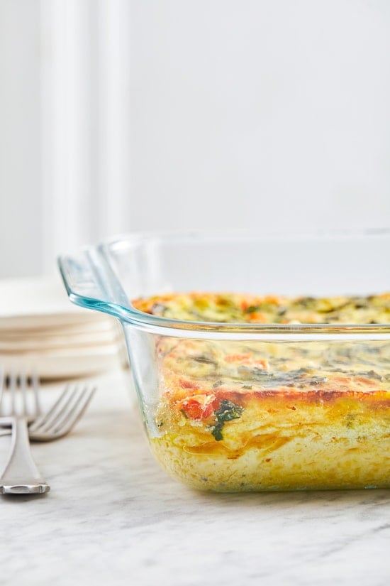 This easy Breakfast Casserole recipe is made with eggs, spinach, tomatoes and Feta cheese and only takes a few minutes to whip up. You can make it ahead of time, so it’s the perfect breakfast egg casserole for Christmas morning or any day!