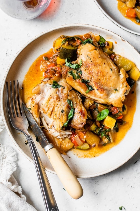 Ratatouille Baked Chicken on a plate with a fork and knife.