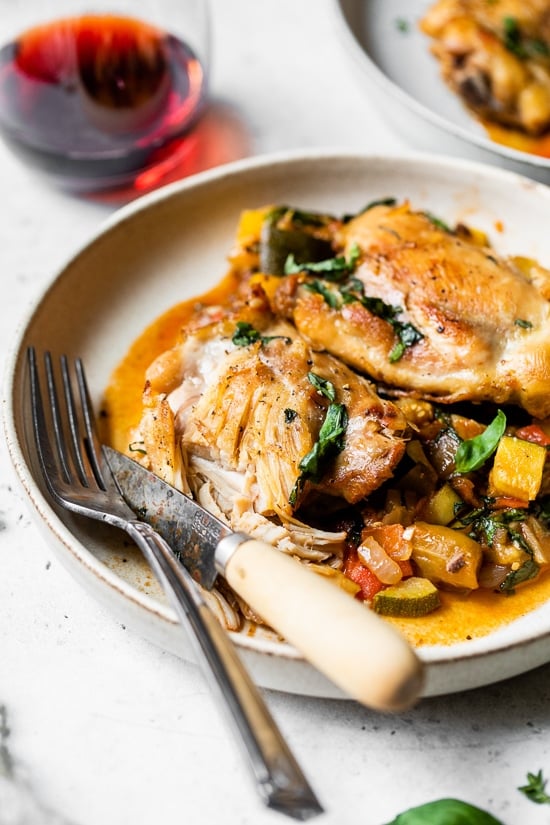 Ratatouille Baked Chicken on a plate with a fork and knife.