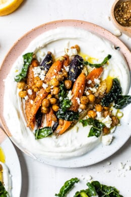 Roasted Carrots and Chickpeas seasoned with za’atar and served over Greek yogurt with lemony kale makes a wonderful side dish or meatless main!