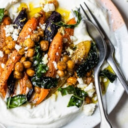 Roasted Carrots and Chickpeas seasoned with za’atar and served over Greek yogurt with lemony kale makes a wonderful side dish or meatless main!