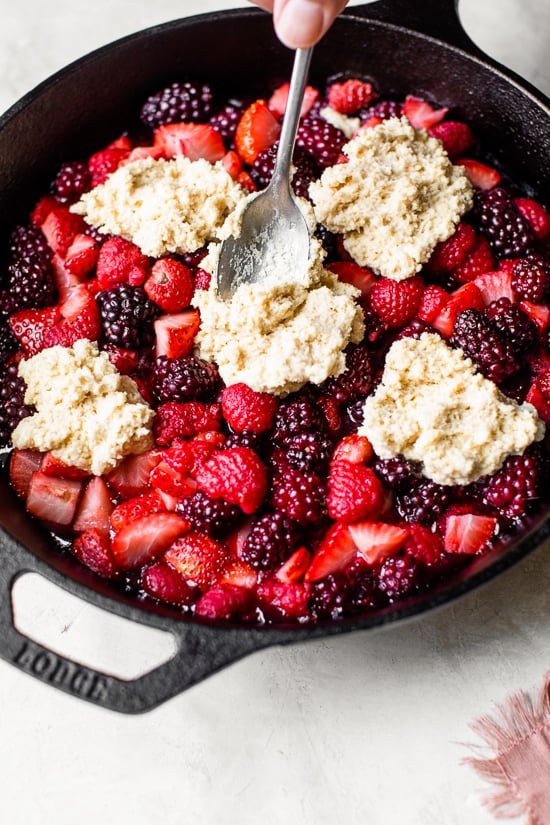 Making a Cobbler with blackberries, raspberries, and strawberries covered with a delicious biscuit topping and baked in a cast iron skillet.