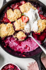Skillet Mixed Berry Buttermilk Cobbler is made with blackberries, raspberries, and strawberries covered with a delicious biscuit topping and baked in a cast iron skillet.