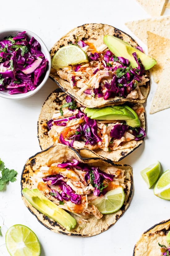 These easy Slow Cooker Chicken Tacos made in the crock pot with chicken breast, salsa, and spices are on repeat in my house!