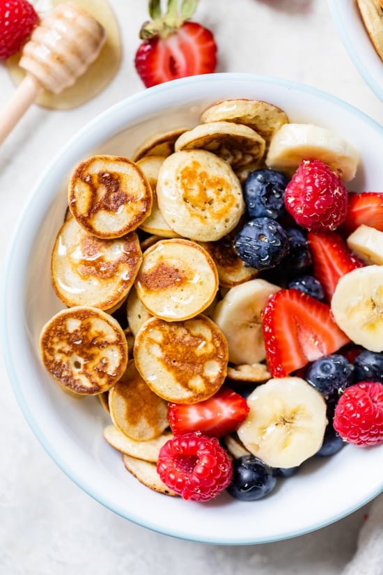 Mini Pancake Cereal is the latest Tiktok trend, so versatile you can serve them with anything you want! I made them healthier with my banana pancake recipe and topped them with tons of fresh fruit.