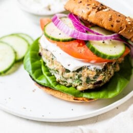 Greek turkey burger with bun, tomatoes, cucumber on a plate