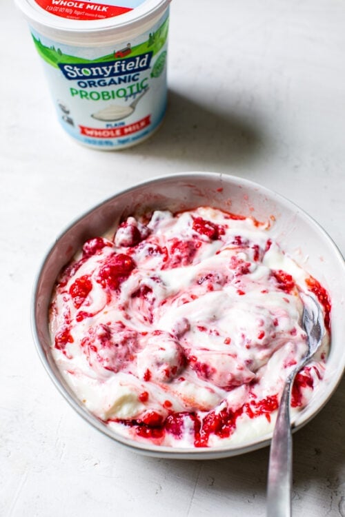 mashed raspberries with yogurt in a bowl