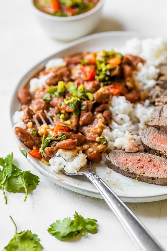 Dominican Beans over rice with aji picante on top and steak on the side.