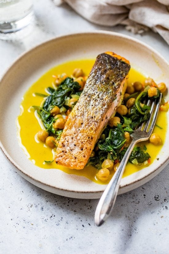salmon on a plate with spinach and chickpeas