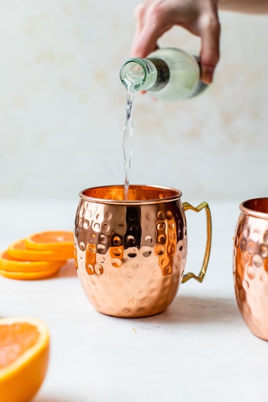 pouring ginger beer into copper mug