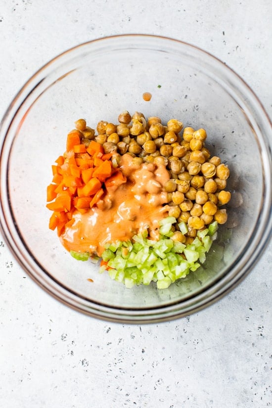 Hummus salad with hot sauce, celery and carrots.