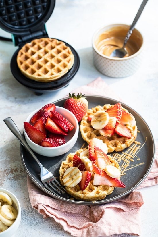 Waffles de avena con fresas, mantequilla de maní y plátanos.