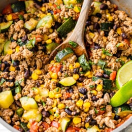 Ground Turkey with Zucchini, Corn, Black Beans and Tomatoes in a skillet.