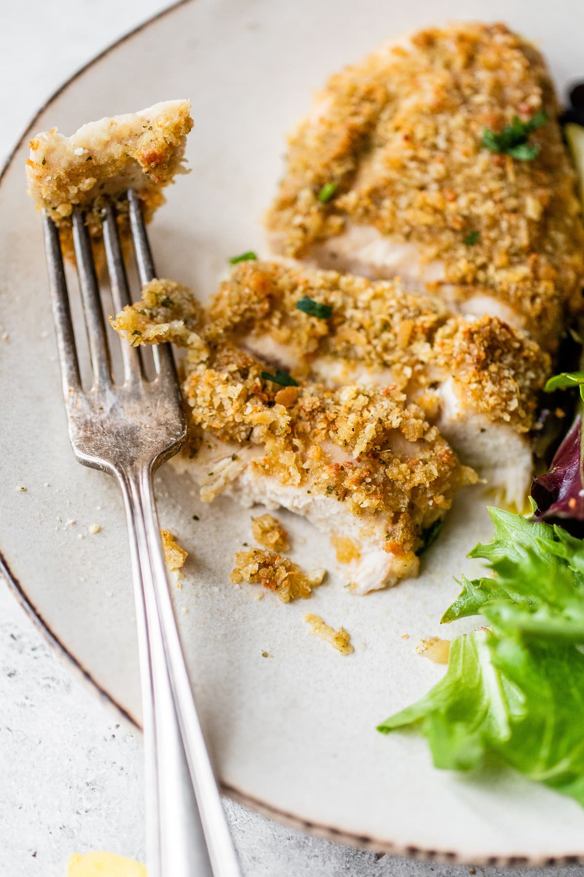 cut up baked chicken breast with lettuce and a fork