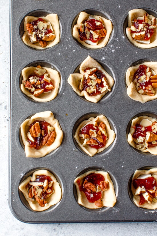 mini muffin tin with brie, jam and pecans