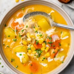 Chicken corn chowder in bowl with spoon.