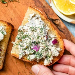 Sardine Salad on toast with a hand