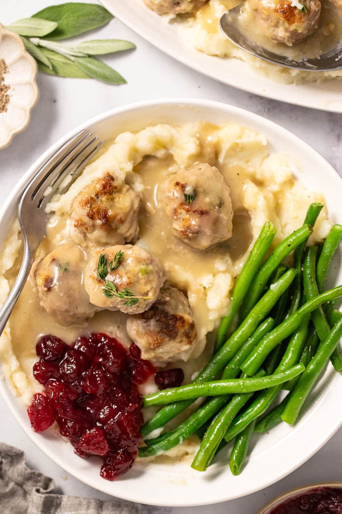 Thanksgiving turkey meatballs made with stuffing mix and fresh herbs, served in homemade gravy over mashed potatoes.